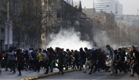 © Reuters. Manifestantes correm de gás lacrimogêneo em Santiago