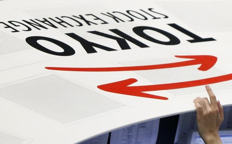 &copy; Reuters An employee of the Tokyo Stock Exchange (TSE) places his hand next to the TSE logo at the bourse in Tokyo