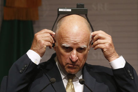 © Reuters. California Governor Jerry Brown adjusts his earpiece during a news conference at Memoria y Tolerancia museum in Mexico City