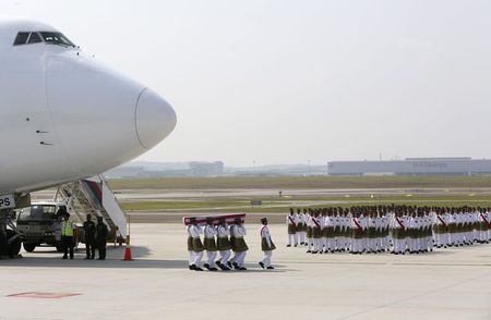 © Reuters. The remains of a victim of the Malaysia Airlines flight MH17 disaster are carried during a repatriation ceremony at the Bunga Raya complex of KLIA airport in Sepan