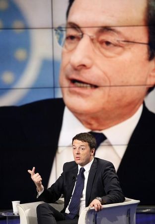 © Reuters. Italy's  Prime Minister Renzi gestures as a picture of Draghi, President of the ECB, is seen on a large screen behind him during television talk show "Porta a Porta" in Rome