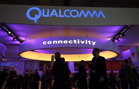 © Reuters. File photo of visitors walking past the Qualcomm stand at the Mobile World Congress in Barcelona