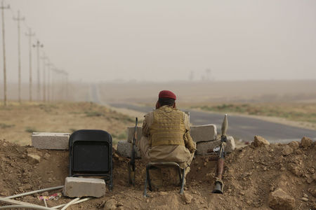 © Reuters. A Kurdish fighter keeps guard while overlooking positions of Islamic State militants near Mosul in northern Iraq