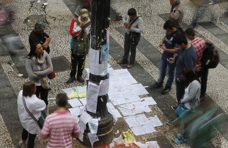 © Reuters. Pessoas observam ofertas de emprego no centro de São Paulo