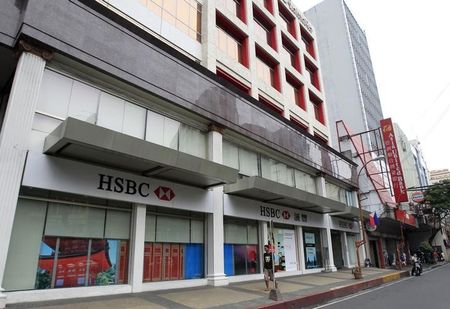 © Reuters. A man walks past an HSBC branch along a main street in Manila