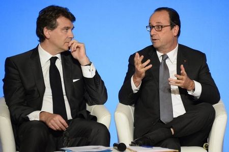 © Reuters. French President Francois Hollande gestures as he speaks with French Economy Minister Arnaud Montebourg during a reception honouring the first 110 laureates of the worldwide innovation challenge "Innovation 2030" at the Elysee Palace in Paris