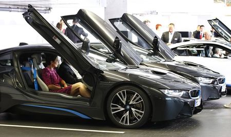 © Reuters. File photo of world's first customers of new BMW i8 plug-in hybrid sports car receiving instructions in Munich