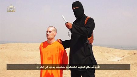 © Reuters. Still image from undated video of a masked Islamic State militant holding a knife speaking next to man purported to be James Foley at an unknown location