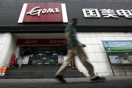 © Reuters. Man walks past a GOME store in Shanghai