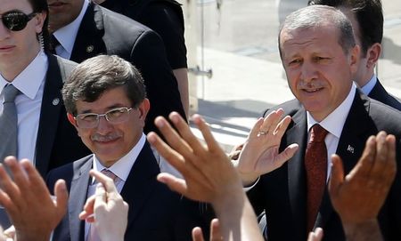 © Reuters. Turkey's Prime Minister Tayyip Erdogan and Foreign Minister Ahmet Davutoglu greet their supporters as they leave Friday prayers in Ankara