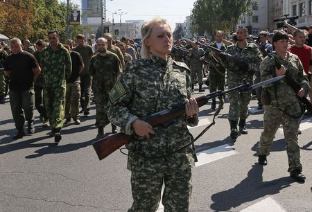 © Reuters. Una separatista filorussa armata scorta una colonna di prigionieri di guerra ucraini a Donetsk