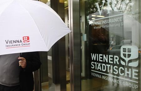 © Reuters. A man holding an umbrella leaves Vienna Insurance Group's headquarters in Vienna