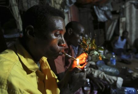 © Reuters. Somali men smoke and chew khat inside a makeshift building at night in Mogadishu