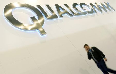 © Reuters. A man walks past a Qualcomm advertising logo at the Mobile World Congress at Barcelona