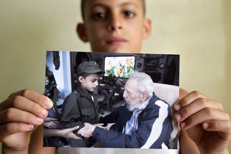 © Reuters. Marlon Méndez, admirador de Fidel Castro, mostra foto dele com Fidel, em San Antonio de los Baños, nos arredores de Havana