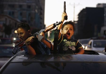 © Reuters. Crianças palestinas comemoram com armas na comemoração pelo que palestinos dizem ter sido uma vitória sobre Israel, após um cessar-fogo em Gaza