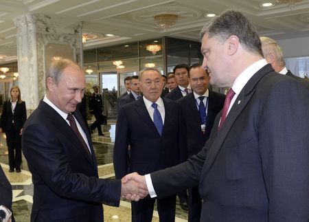 © Reuters. Presidente russo, Vladimir Putin, cumprimenta presidente da Ucrânia, Petro Poroshenko, em Minsk