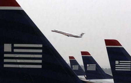 © Reuters. An American Eagle jet takes off as U.S. Airways jets are lined up at Reagan National Airport in Washington