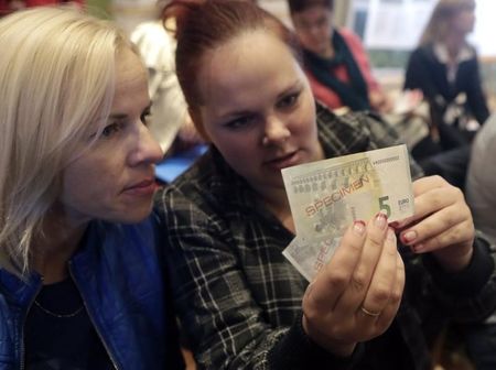 © Reuters. Women holding  euro banknotes during a workshop in Salacgriva September 24, 2013.