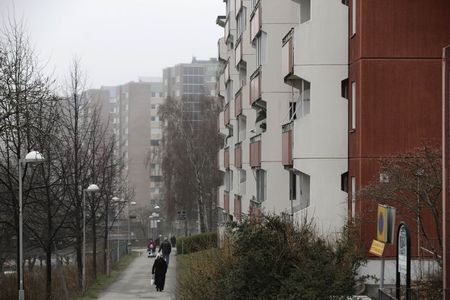 © Reuters. People walk past apartment blocks in Stockholm