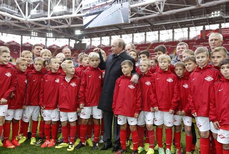 © Reuters. Presidente russo, Vladimir Putin, com jovens jogadores de futebol em visita ao novo estádio do Spartak, em Moscou