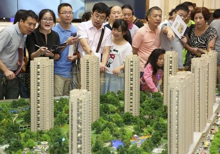 © Reuters. Customers look at a model of a new residential compound, at a showroom of Longfor Properties Co. Ltd., in Hangzhou