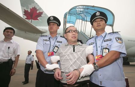 © Reuters. Then Chinese fugitive Lai Changxing is escorted back to Beijing from Canada, at Beijing International Airport