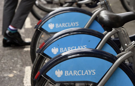 © Reuters. A worker walks between public hire bikes, sponsored by Barclays, in the city of London