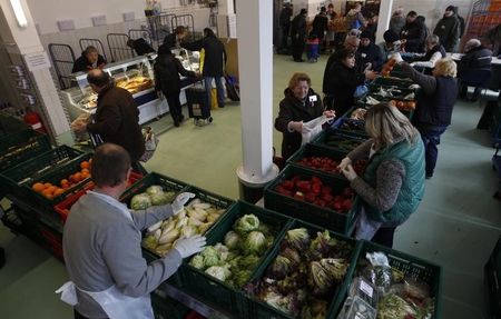 © Reuters. People receive food that is either too old or not looking nice enough for sale at the non-profit Dortmund food bank "Dortmunder Tafel"  in the western German city of Dortmund