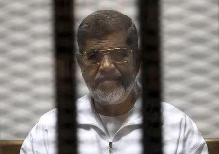 © Reuters. Ousted Egyptian President Mursi is seen behind bars during his trial at a court in Cairo
