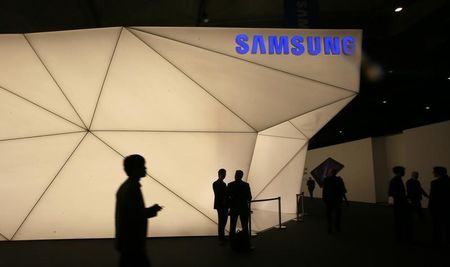 © Reuters. Visitors walk past the Samsung stand at the Mobile World Congress in Barcelona