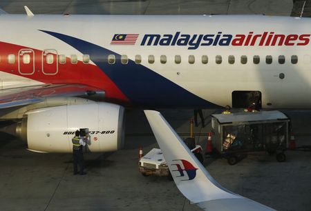 © Reuters. A member of ground crew works on a Malaysia Airlines Boeing 737-800 airplane on the runway at Kuala Lumpur International Airport in Sepang