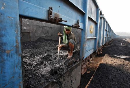 © Reuters. File photo of a worker unloading coal from a goods train at a railway yard in Chandigarh