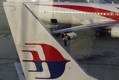 © Reuters. An airport worker walks between Malaysia Airlines planes at Kuala Lumpur International Airport