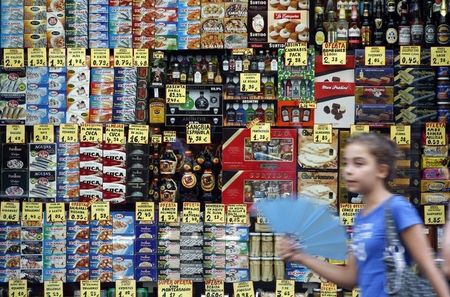 © Reuters. A girl walks past a grocery shop in central Barcelona