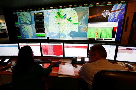 © Reuters. Staff at satellite communications company Inmarsat work in front of a screen showing subscribers using their service throughout the world, at their headquarters in London