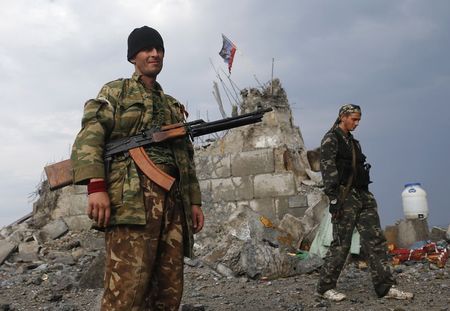 © Reuters. Separatistas pró-Rússia caminham por um memorial de guerra em ruínas em Savur-Mohyla, um monte a leste da cidade de Donetsk, na Ucrânia