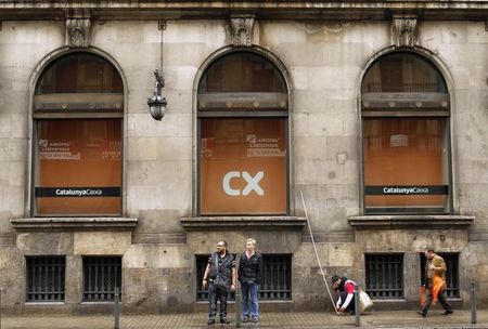 © Reuters. People are seen in front of the Catalunya Caixa bank at its headquarters in Barcelona
