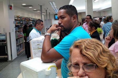 © Reuters. People wait to buy medicines at a drugstore in Caracas