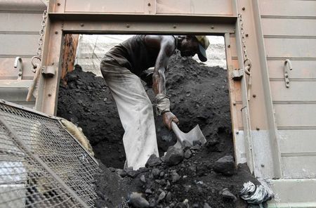 © Reuters. File photo of a labourer unloading coal from a supply truck at a yard on outskirts of western Indian city of Ahmedabad