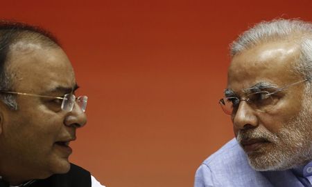 © Reuters. Indian PM Modi speaks with Finance Minister Jaitley during the launch of the Jan Dhan Yojana, or the Scheme for People's Wealth, in New Delhi