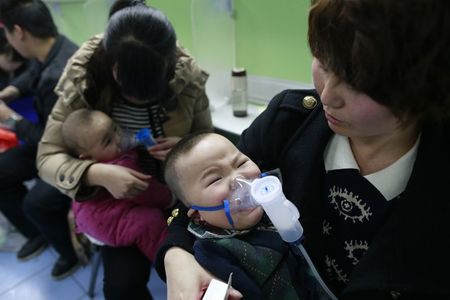 © Reuters. File photo shows children with respiratory illness receiving treatment at a hospital in Beijing