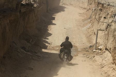 © Reuters. A rebel fighter rides a motorcycle inside a rebel-made tunnel connecting to Zamalka in Jobar, a suburb of Damascus, which activists claim has been undergoing violent clashes between forces loyal to Syria's President Bashar al-Assad and rebel fighters