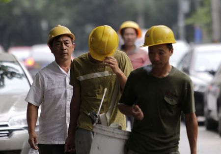 © Reuters. Workers walk toward a construction site in Beijing