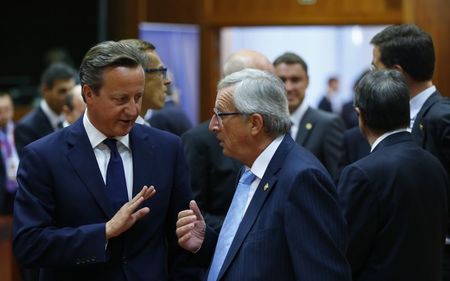 © Reuters. Britain's PM Cameron talks with newly elected European Commission President Juncker at the start of a European Union summit in Brussels