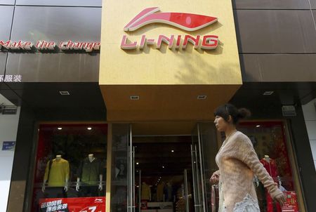 © Reuters. File picture of a woman walking past a Li Ning sportswear store in Huaibei