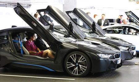 © Reuters. World's first eight costumers of new BMW i8 plug-in hybrid sports car receive instructions during official delivery in Munich