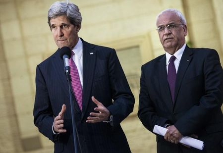 © Reuters. Palestinian negotiator Erekat listens as U.S. Secretary of State Kerry speaks to the media in Ramallah