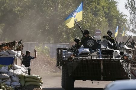 © Reuters. Ukrainian servicemen ride in an armoured vehicle near Kramatorsk