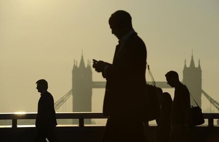 © Reuters. Workers cross London Bridge, with Tower Bridge seen behind, during the morning rush hour in London